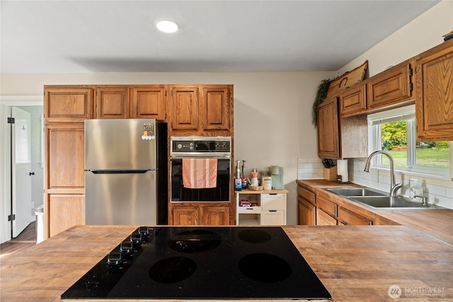 85 Rustemeyer Rd, Aberdeen, WA 98520 - kitchen with black appliances, a sink, decorative backsplash, brown cabinetry, and recessed lighting
