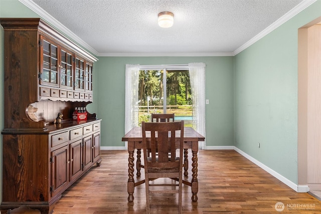 3123 163rd St E, Tacoma, WA 98446 - dining room featuring wood finished floors, a textured ceiling, baseboards, and ornamental molding
