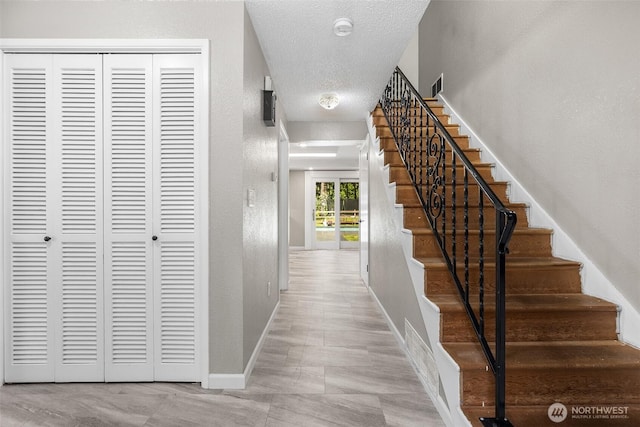 3123 163rd St E, Tacoma, WA 98446 - hallway with stairs, baseboards, a textured ceiling, and a textured wall