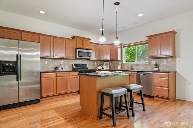 4135 240th Pl SE, Bothell, WA 98021 - kitchen featuring stainless steel appliances, a kitchen island, light wood-style floors, a kitchen breakfast bar, and recessed lighting