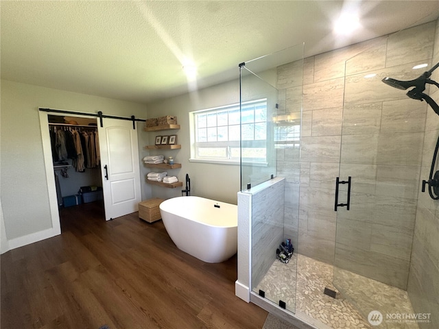 22 Rooster Flats Rd, Oroville, WA 98844 - full bathroom featuring a stall shower, a freestanding bath, wood finished floors, a spacious closet, and a textured ceiling