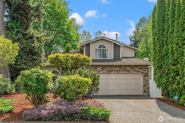 view of front of home with an attached garage, stone siding, and asphalt driveway