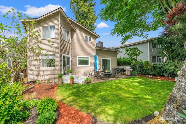 back of house featuring a patio and a yard