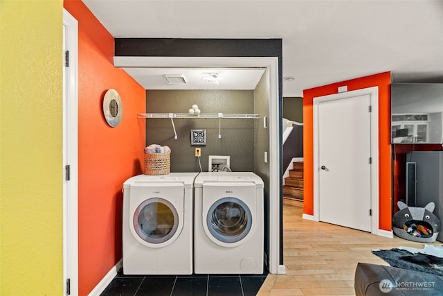 clothes washing area featuring independent washer and dryer and baseboards