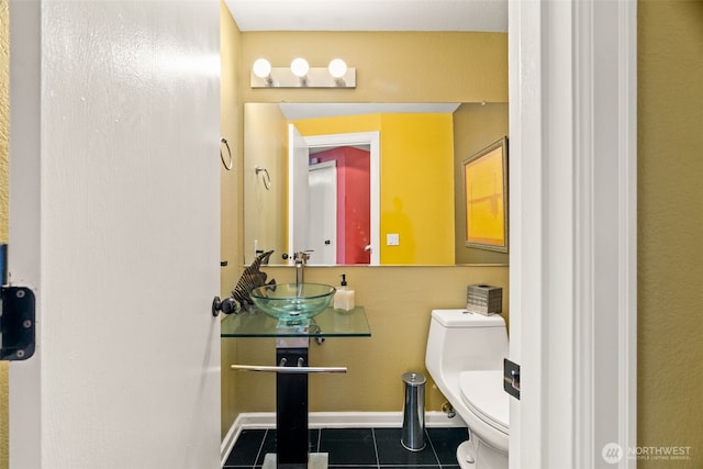 bathroom featuring tile patterned flooring, a sink, toilet, and baseboards
