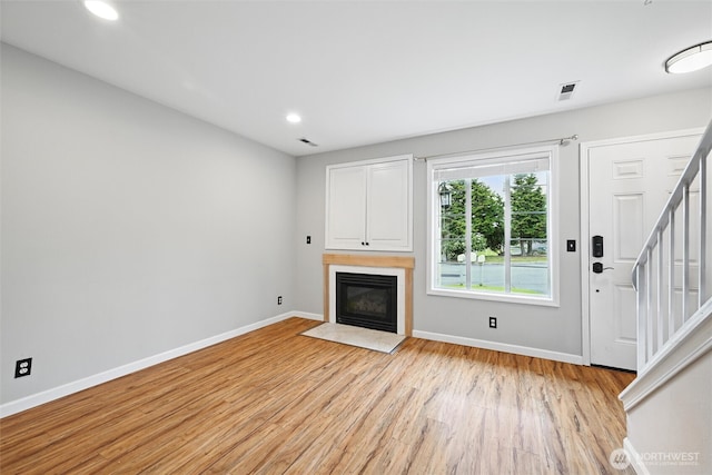 3454 Deer Pointe Ct, Bellingham, WA 98226 - unfurnished living room featuring light wood finished floors, stairs, baseboards, a fireplace with flush hearth, and recessed lighting