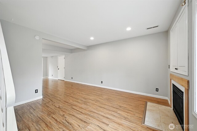 3454 Deer Pointe Ct, Bellingham, WA 98226 - unfurnished living room featuring light wood-style flooring, a fireplace with flush hearth, baseboards, and recessed lighting