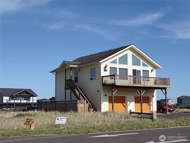 rear view of property with an attached garage and a wooden deck
