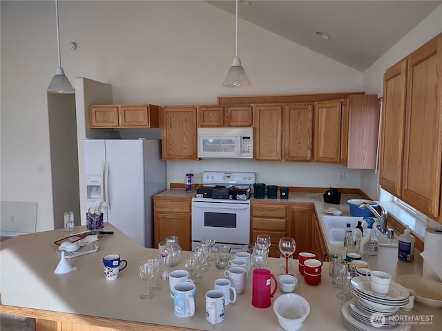 kitchen with white appliances, a sink, vaulted ceiling, pendant lighting, and a peninsula