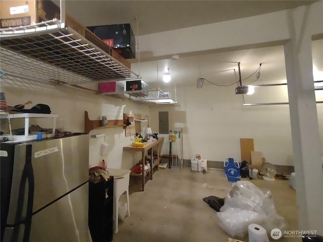 garage with freestanding refrigerator, electric panel, and a garage door opener