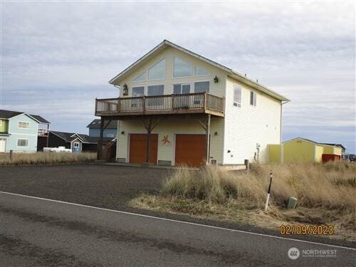 1400 Ocean Shores Blvd SW, Ocean Shores, WA 98569 - view of front of house with dirt driveway, a deck, and a garage