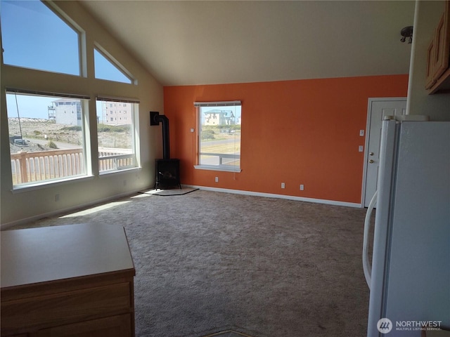 1400 Ocean Shores Blvd SW, Ocean Shores, WA 98569 - unfurnished living room with a wood stove, vaulted ceiling, and carpet