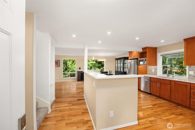 10504 Dixon Dr S, Seattle, WA 98178 - kitchen featuring stainless steel appliances, a sink, light wood-style flooring, open shelves, and recessed lighting