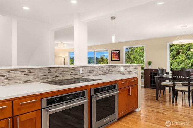 10504 Dixon Dr S, Seattle, WA 98178 - kitchen with oven, tasteful backsplash, light wood finished floors, light countertops, and recessed lighting