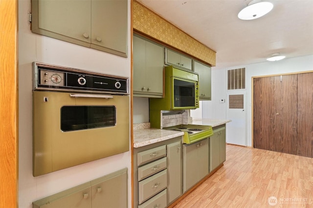 3213 85th St S Unit 48, Lakewood, WA 98499 - kitchen featuring oven, green cabinetry, light countertops, light wood-style floors, and stovetop