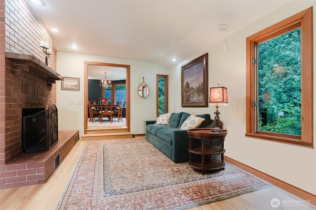 3246 Goshen Rd, Bellingham, WA 98226 - living room featuring wood finished floors, a brick fireplace, a chandelier, recessed lighting, and lofted ceiling