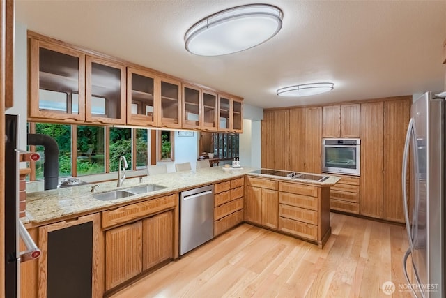 3246 Goshen Rd, Bellingham, WA 98226 - kitchen with stainless steel appliances, light wood finished floors, glass insert cabinets, a peninsula, and light stone counters