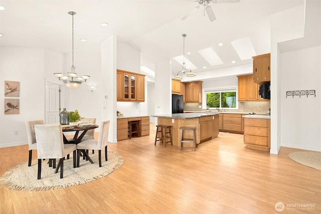 4415 Harborview Dr, Blaine, WA 98230 - kitchen with black appliances, a center island, light wood-style floors, vaulted ceiling, and a breakfast bar