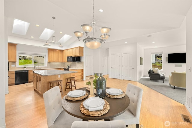 4415 Harborview Dr, Blaine, WA 98230 - dining space featuring lofted ceiling, light wood-style floors, a skylight, healthy amount of natural light, and a chandelier