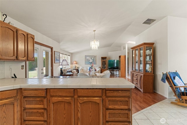 695 S Lyle Ave, East Wenatchee, WA 98802 - kitchen featuring open floor plan, a chandelier, a peninsula, brown cabinets, and hanging light fixtures