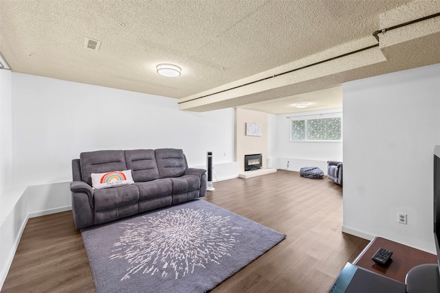 2202 28th Ave SE, Puyallup, WA 98374 - living room featuring a glass covered fireplace, a textured ceiling, wood finished floors, and baseboards