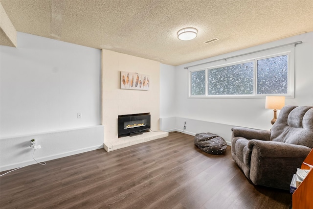2202 28th Ave SE, Puyallup, WA 98374 - living area with wood finished floors, a glass covered fireplace, baseboards, and a textured ceiling
