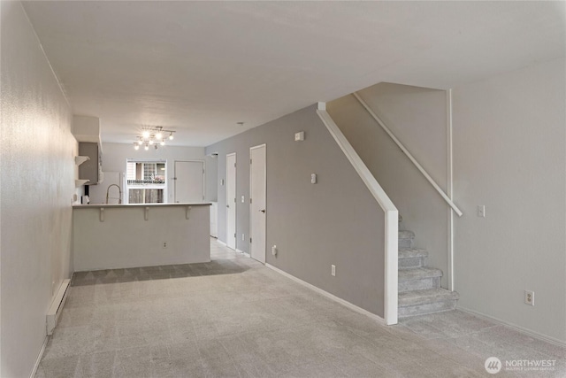 9817 132nd Street Ct E Unit B, Puyallup, WA 98373 - unfurnished living room with stairway, light carpet, baseboard heating, and a sink