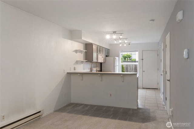 9817 132nd Street Ct E Unit B, Puyallup, WA 98373 - kitchen featuring a baseboard radiator, white appliances, a peninsula, a sink, and a chandelier