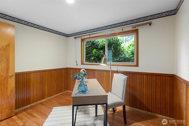 home office featuring a wainscoted wall, light wood-type flooring, and wood walls