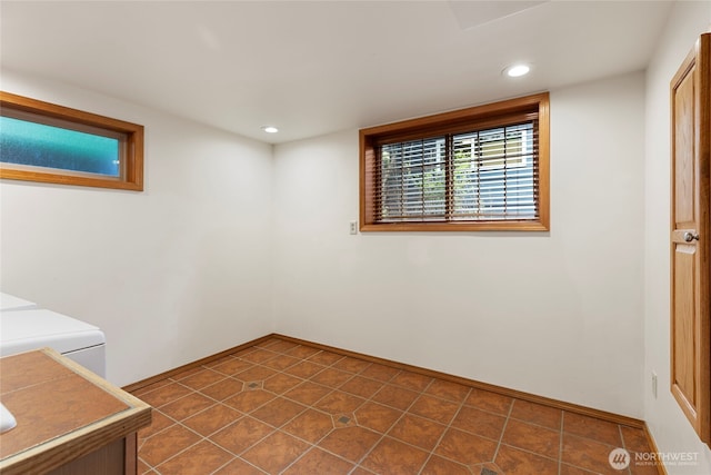 empty room featuring recessed lighting, baseboards, and dark tile patterned floors