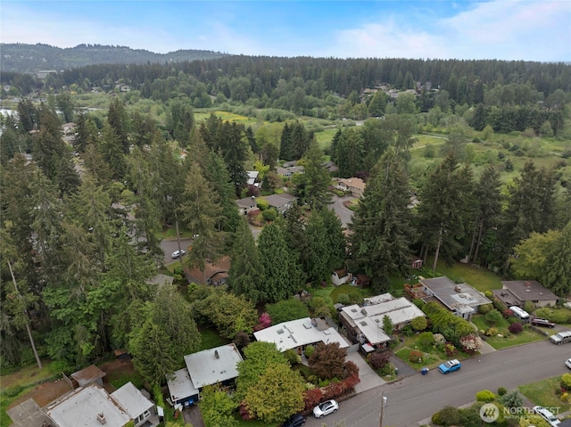aerial view of property's location with a heavily wooded area and nearby suburban area