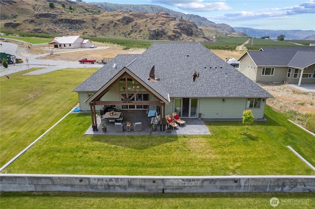 179 N Shore Dr, Orondo, WA 98843 - rear view of property with a patio, a shingled roof, a mountain view, and a lawn