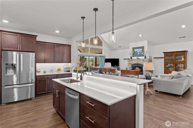 179 N Shore Dr, Orondo, WA 98843 - kitchen featuring appliances with stainless steel finishes, a sink, a fireplace, light countertops, and wood finished floors