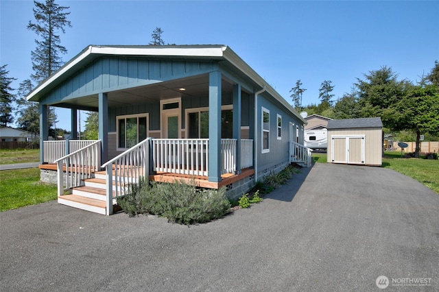 114 Mark Ct SE, Ocean Shores, WA 98569 - view of front of property featuring a porch, a shed, an outbuilding, and board and batten siding