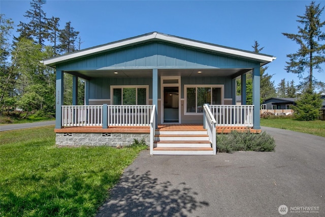 114 Mark Ct SE, Ocean Shores, WA 98569 - view of front facade with a porch, board and batten siding, and a front yard