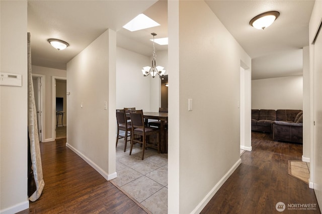 5510 83rd Ave W, University Place, WA 98467 - hallway with a skylight, wood finished floors, a chandelier, and baseboards