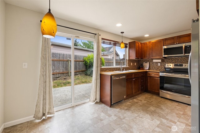 5510 83rd Ave W, University Place, WA 98467 - kitchen with appliances with stainless steel finishes, a sink, tasteful backsplash, pendant lighting, and baseboards