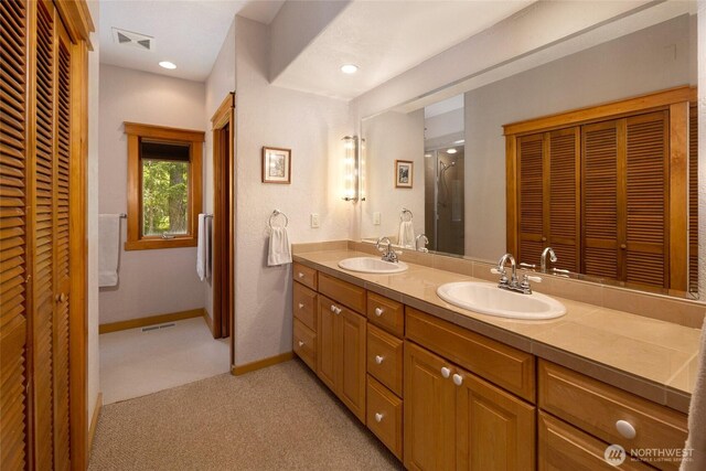 591 Wold Rd, Friday Harbor, WA 98250 - bathroom with a closet, double vanity, a shower with door, and baseboards