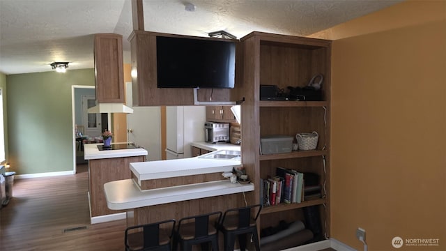 1900 Broadway Ave Unit 2, Hoquiam, WA 98550 - kitchen featuring baseboards, a textured ceiling, dark wood-style floors, a peninsula, and light countertops