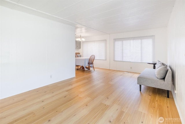 sitting room with light wood-style flooring and a chandelier