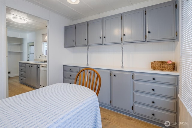 bedroom featuring a sink, light wood-type flooring, and ensuite bath
