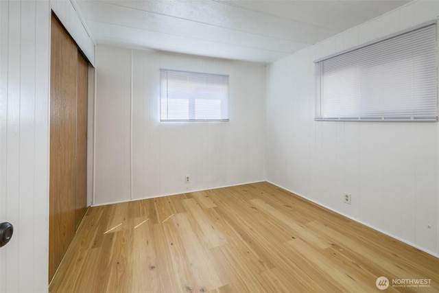 unfurnished bedroom with light wood-type flooring and a closet