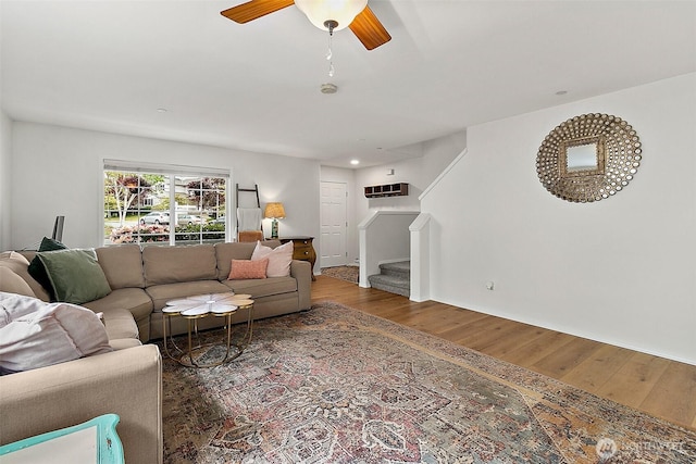 living room featuring stairway, wood finished floors, and ceiling fan
