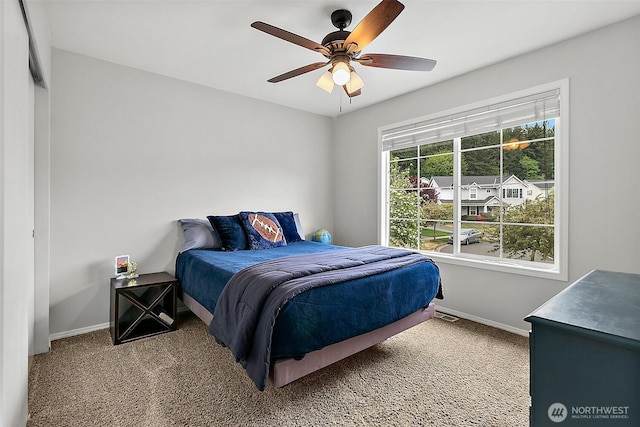 carpeted bedroom featuring baseboards and ceiling fan