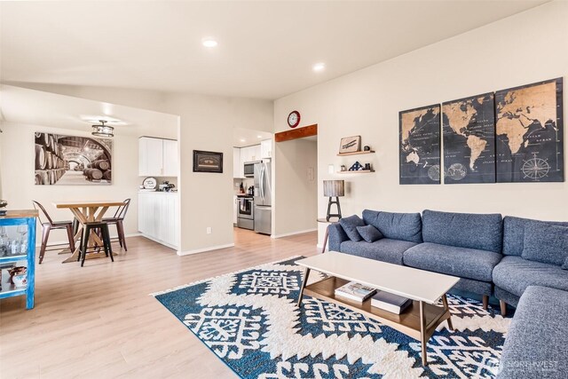 living room with light wood-style floors, recessed lighting, and baseboards