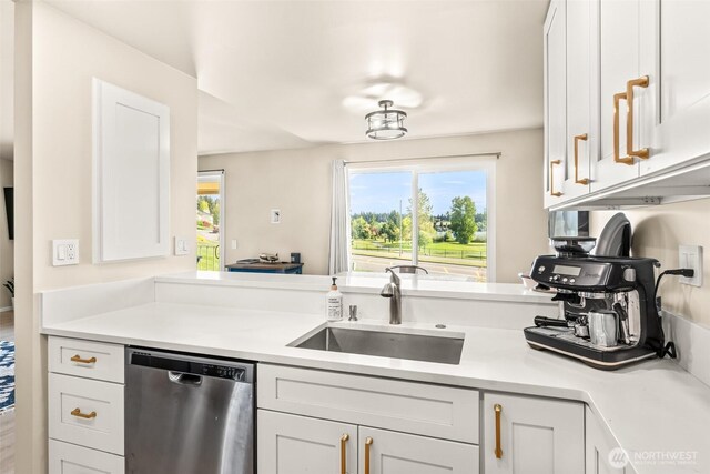 kitchen featuring dishwasher, a sink, light countertops, and white cabinetry