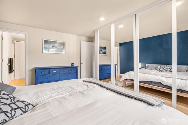 bedroom with wood finished floors, recessed lighting, and connected bathroom
