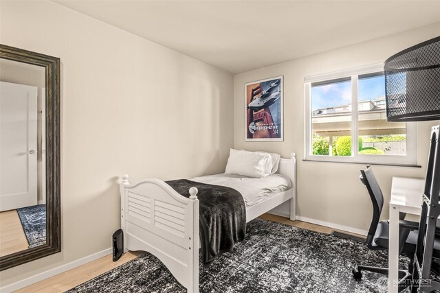 bedroom featuring wood finished floors and baseboards