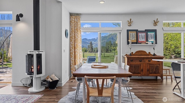 dining area with a mountain view, dark wood finished floors, and a wood stove