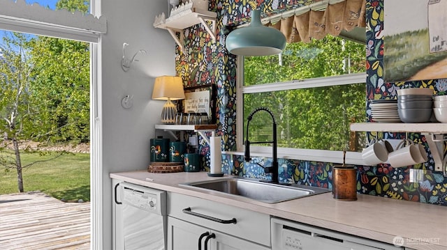 kitchen with dishwasher, a sink, white cabinets, and open shelves